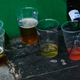Half drank cups of beer, wine, and alcohol on the ground